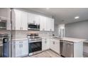Modern kitchen with stainless steel appliances, white cabinets, and quartz countertops; ready for cooking at 1013 Cannes Dr, Kissimmee, FL 34759
