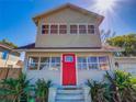 Charming two-story home featuring a red front door and mature landscaping at 103 W Maple St, Davenport, FL 33837
