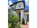 Home's front entrance with neutral paint, a gray door and manicured plants at 1220 Hilltop Pl # 1220, St Cloud, FL 34772