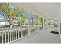 Spacious front porch with elegant white railings and columns, offering views of the street and neighborhood at 1251 Aquila Loop, Celebration, FL 34747