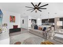 Open-concept living room with stylish decor, fan, and seamless flow into kitchen at 1431 Lassen St, Haines City, FL 33844