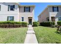 Charming townhome with a green door and lush landscaping leading to a well-kept lawn at 1615 Reflection Cv, St Cloud, FL 34771
