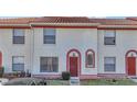 Charming townhome with a red door, cream stucco and red trim plus nicely kept front lawn area at 1631 Little Falls Cir # 92, Orlando, FL 32807