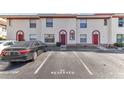 Charming townhome with a red door, cream stucco and red trim plus reserved visitor parking at 1631 Little Falls Cir # 92, Orlando, FL 32807