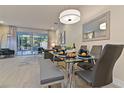 Open-concept dining area with glass table, bench seating, and access to screened in outdoor living at 17220 Blessing Dr, Clermont, FL 34714