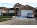 Two-story home boasts an attached garage and simple landscaping at 2244 Mallard Creek Cir, Kissimmee, FL 34743