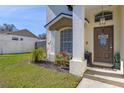 Close up of the front door and window of a charming home with well manicured landscaping at 2313 Duncan Trl, Clermont, FL 34714
