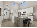 Spacious kitchen with white cabinets, granite counters, stainless steel appliances and tiled floor at 2313 Duncan Trl, Clermont, FL 34714
