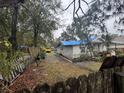 An overgrown backyard filled with fallen leaves and a detached garage at 2316 W Parker St, Lakeland, FL 33815