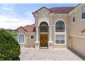 Close up of a tan-colored house showing the pillars, arched windows, and a double-door entrance at 2375 Pinehurst Ct, Davenport, FL 33837