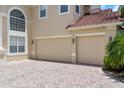 A long brick driveway going up to the two-car garage of a light brown house at 2375 Pinehurst Ct, Davenport, FL 33837