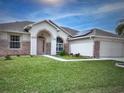 Inviting single-story home with lush lawn, brick detail, and archway entry at 2438 Winfield Dr, Kissimmee, FL 34743