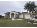 Charming single-story home featuring a well-manicured lawn, brick accents, and mature palm trees at 2438 Winfield Dr, Kissimmee, FL 34743