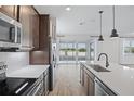 Gourmet kitchen with stainless steel appliances, island with sink and backyard lake view at 276 Hilltop Bloom Loop, Haines City, FL 33844