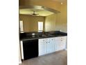 Kitchen featuring white cabinetry, black appliances, and granite countertops at 2981 Winding Trl, Kissimmee, FL 34746