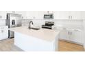 Modern kitchen with white cabinetry, stainless steel appliances, and a large center island at 2985 Gavin Sky Dr, Kissimmee, FL 34744