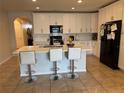 Modern kitchen featuring white cabinetry, stainless steel appliances, and an island with seating at 3082 Royal Tern Dr, Winter Haven, FL 33881