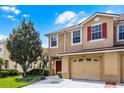 Inviting townhome displaying red shutters, attached garage, and manicured landscaping at 3102 Ashland N Ln # 3152, Kissimmee, FL 34741