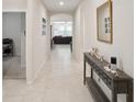 Inviting hallway with neutral tones leading to a spacious living area, showcasing modern decor and ample lighting at 3142 Hill Point St, Minneola, FL 34715