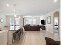 Open-concept living room and kitchen with a large island, stainless steel appliances, and modern finishes at 3142 Hill Point St, Minneola, FL 34715