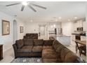 Bright, open living space showcasing a comfortable sectional sofa, leading to a modern kitchen and dining area at 3142 Hill Point St, Minneola, FL 34715