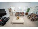 Comfortable living room with a large window and neutral carpeting, furnished with colorful sofas and decor at 466 Peppermill Cir, Kissimmee, FL 34758