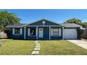 Charming single-story home features a blue exterior, white trim, and a well-maintained lawn at 4861 Haines Circle, Orlando, FL 32822