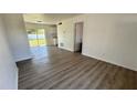 Bright living room with stylish gray wood flooring and sliding glass doors to the backyard at 4861 Haines Circle, Orlando, FL 32822
