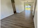 Bright living room with stylish gray wood flooring and sliding glass doors to the backyard at 4861 Haines Circle, Orlando, FL 32822