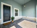 Inviting front porch featuring brick pavers, a black front door, and a decorative hanging light fixture at 509 Lakeview Dr, Poinciana, FL 34759