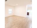 Bright living room with light-colored wood-look flooring and window at 551 Meadow Bend Dr, Davenport, FL 33837