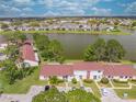 Expansive aerial view overlooking the community, lush greenery, lake, and residential homes at 86 Pine Island Cir, Kissimmee, FL 34743