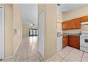 Kitchen featuring tile floors, wood cabinets, granite counters, and white appliances overlooking the living room at 86 Pine Island Cir, Kissimmee, FL 34743