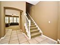 The foyer has tile floors, a staircase with white railings, and an arched doorway leading to a living room at 1027 Banks Rose St, Celebration, FL 34747