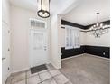 Elegant foyer with tile flooring and stylish black and white accent wall at 1027 Banks Rose St, Celebration, FL 34747
