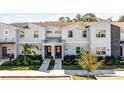 View of a modern townhome exterior featuring well-maintained landscaping, twin front doors, and neutral-toned facade at 2569 Reading Trl, Kissimmee, FL 34746