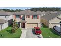 Two-story home with a two-car garage, red shutters, and a well-maintained lawn at 260 Willow Bend Dr, Davenport, FL 33897