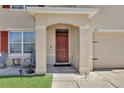 Inviting front porch with seating area and an arched entryway to the front door at 260 Willow Bend Dr, Davenport, FL 33897