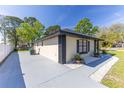 Well-maintained home with neutral paint, black accents, gray driveway, and a yard decorated with river rock and green plants at 2931 Chilton St, Deltona, FL 32738