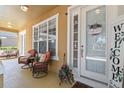 Cozy front porch with two chairs, a welcome sign, and decorative plants offering a relaxing outdoor space at 3304 Cat Brier Trl, Harmony, FL 34773