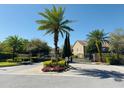 View of gated community entrance surrounded by palm trees and manicured landscaping at 3655 Zuma Way, Orlando, FL 32839