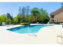 Sparkling community pool surrounded by lush green trees and chaise lounge seating at 3655 Zuma Way, Orlando, FL 32839