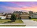 Charming single-story home featuring a manicured lawn, mature shrubbery, and a two-car garage at 3705 Apopka Ridge Cir, Apopka, FL 32703