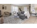 Inviting living room with a plush grey sectional, stylish rug, and ample natural light at 407 Reserve Dr, Davenport, FL 33896