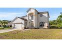 Two-story home with a stucco exterior, arched entryway, and an attached two-car garage at 5516 Willow Bend Trl, Kissimmee, FL 34758