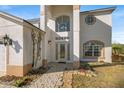 Close-up of the front entrance with glass paneled door, arched window, and stone walkway at 5516 Willow Bend Trl, Kissimmee, FL 34758