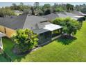 An enclosed backyard with a screened-in porch, palm trees and green lawn at 722 Portofino Dr, Kissimmee, FL 34759