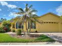 Charming single-story home featuring a well-maintained lawn with beautiful palm trees and a two-car garage at 722 Portofino Dr, Kissimmee, FL 34759