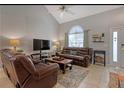 Inviting living room with high ceilings, neutral paint, and comfortable leather furniture at 723 Allison Ave, Davenport, FL 33897