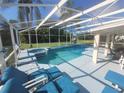 A refreshing screened-in pool with an attached spa and comfortable lounge seating at 723 Allison Ave, Davenport, FL 33897